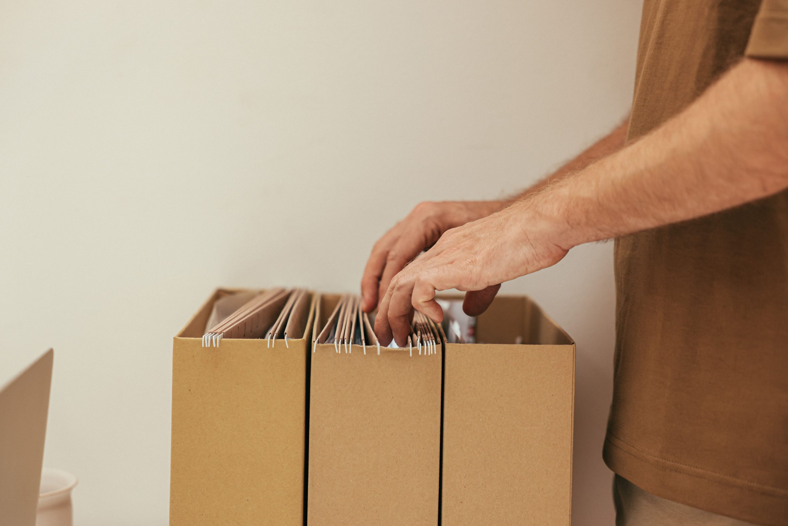 Personne triant des dossiers dans boîtes carton