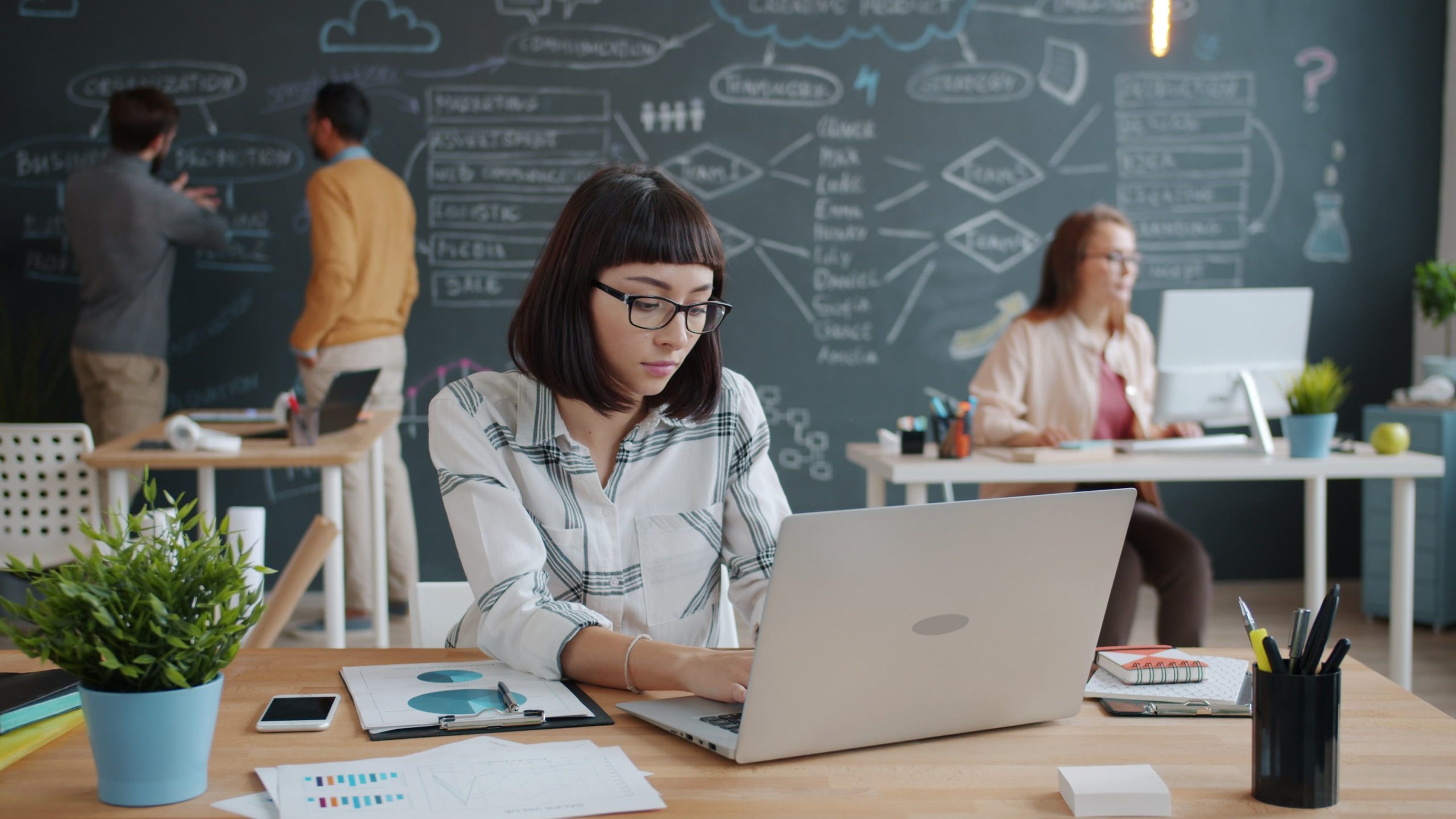 Professionnels discutent stratégie entreprise au tableau blanc
