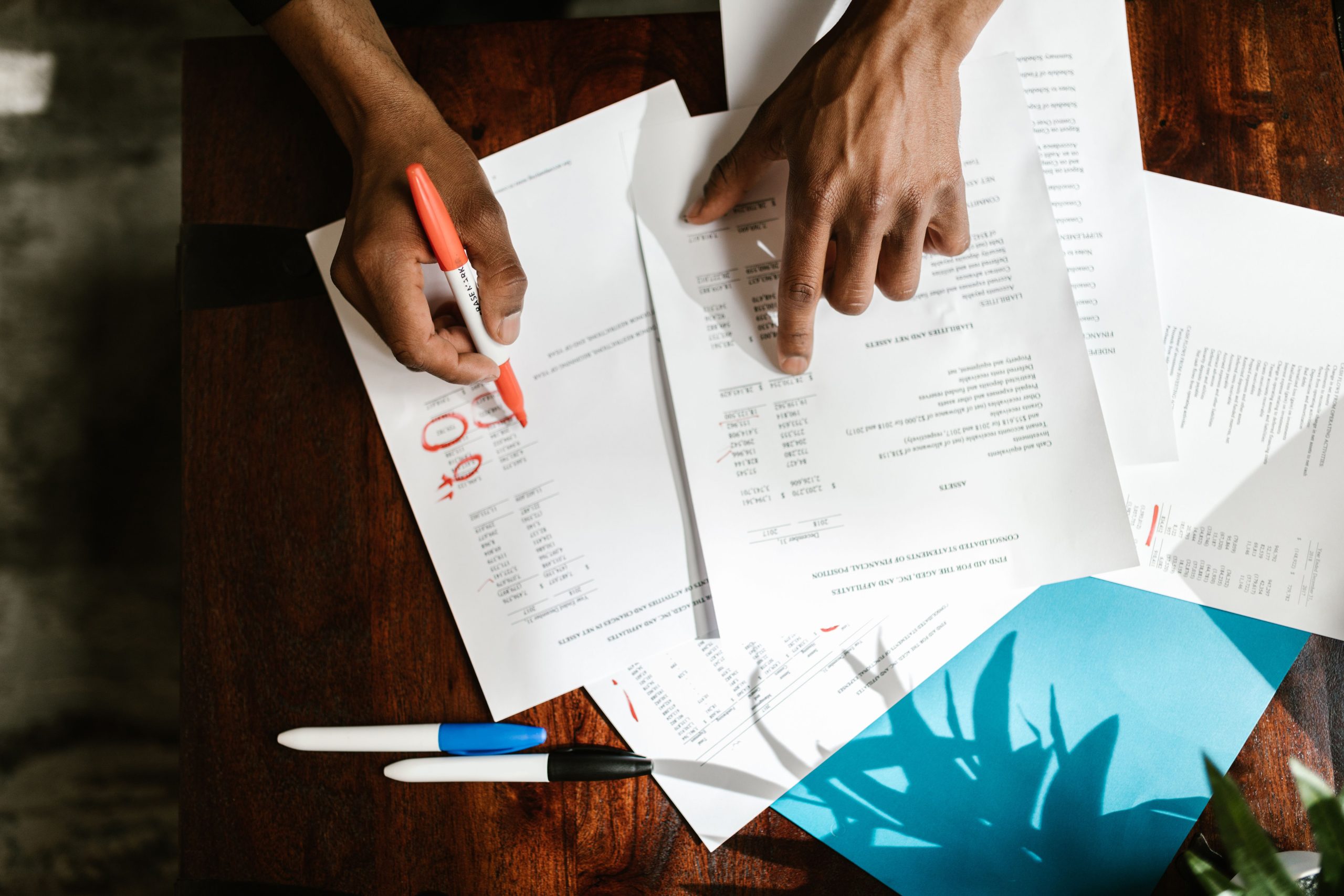 Mains examinant des documents financiers sur bureau