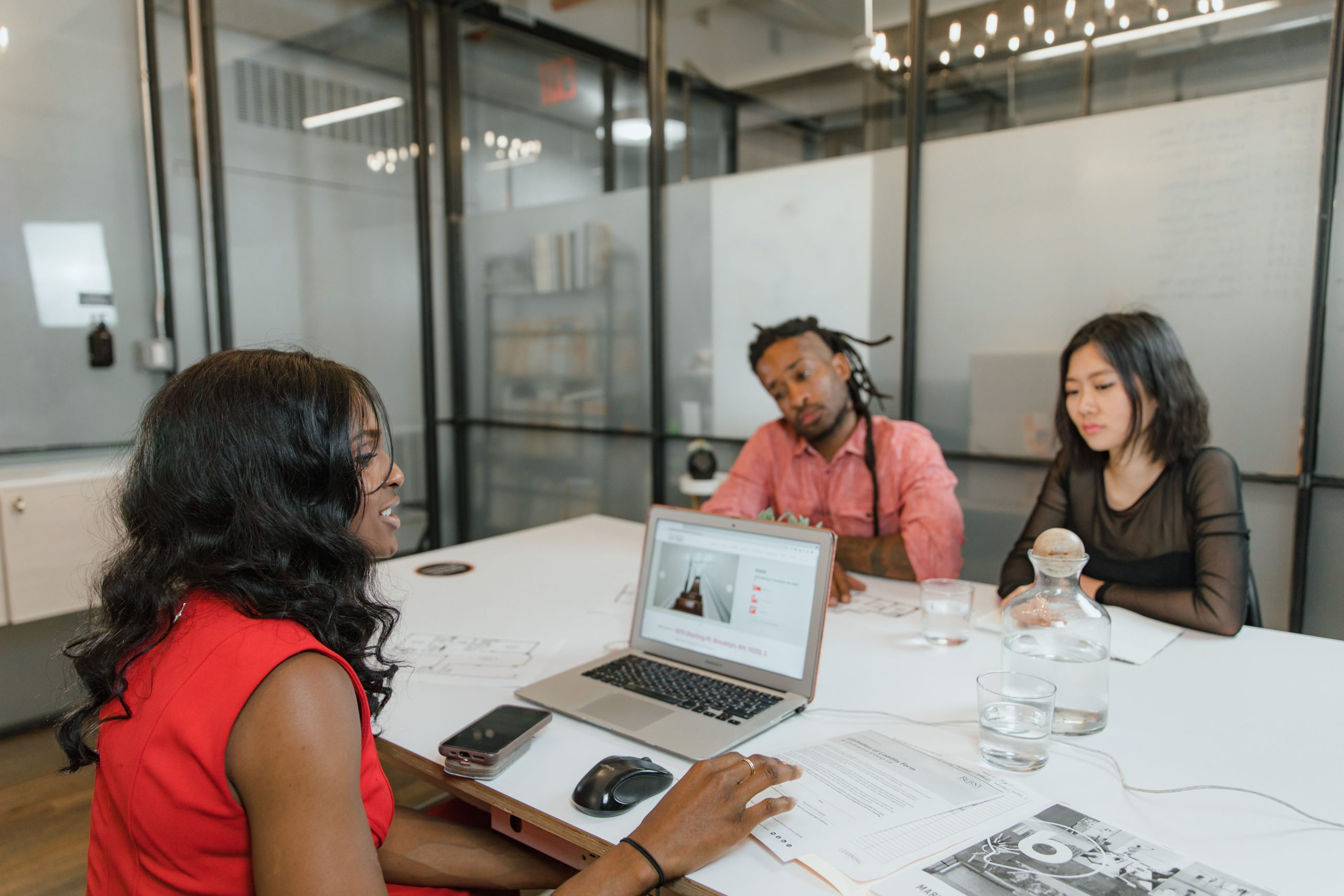 Equipe diverse collabore en discutant sur ordinateurs portables