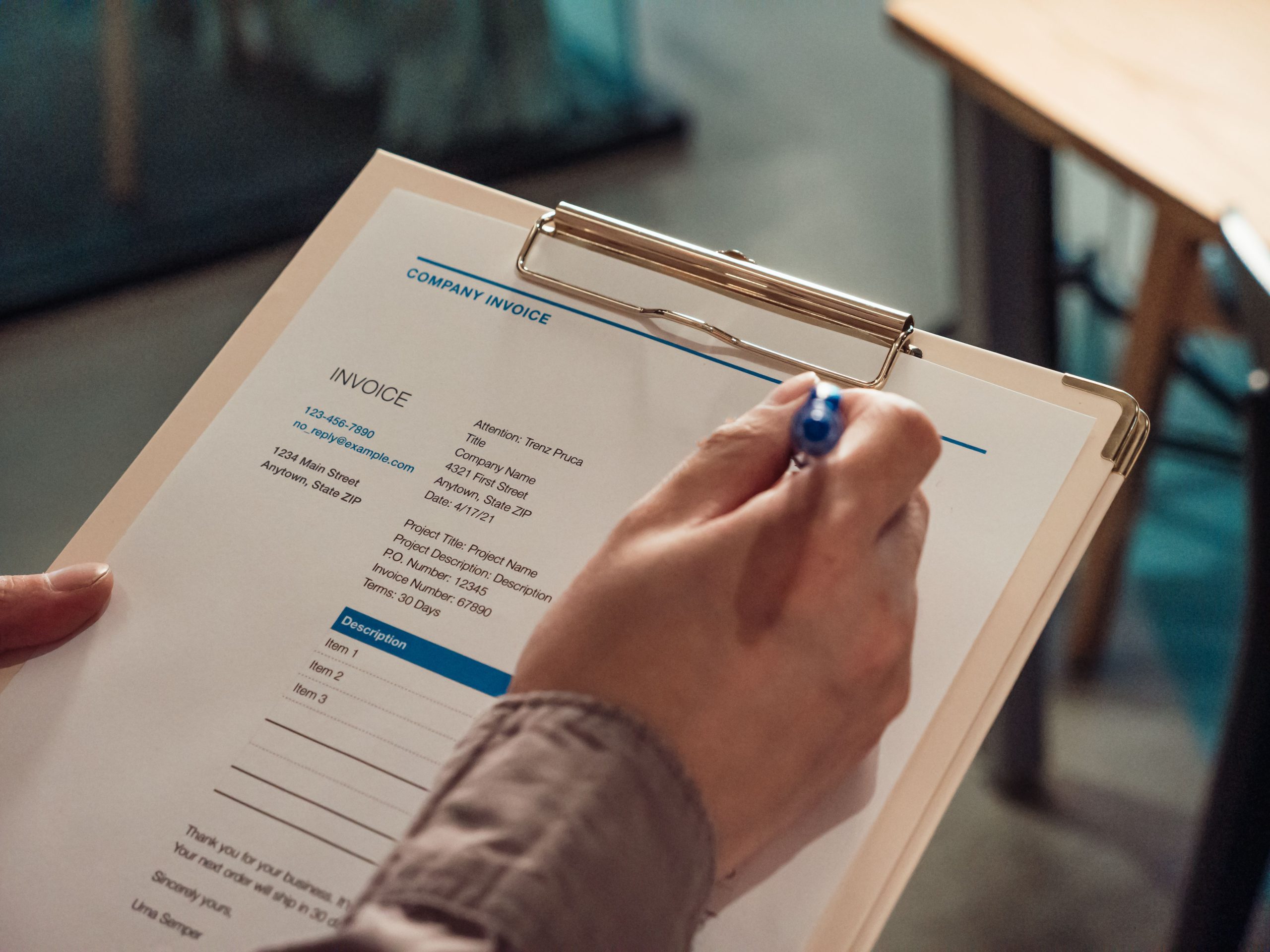 Main tenant une facture d'entreprise sur un presse-papiers