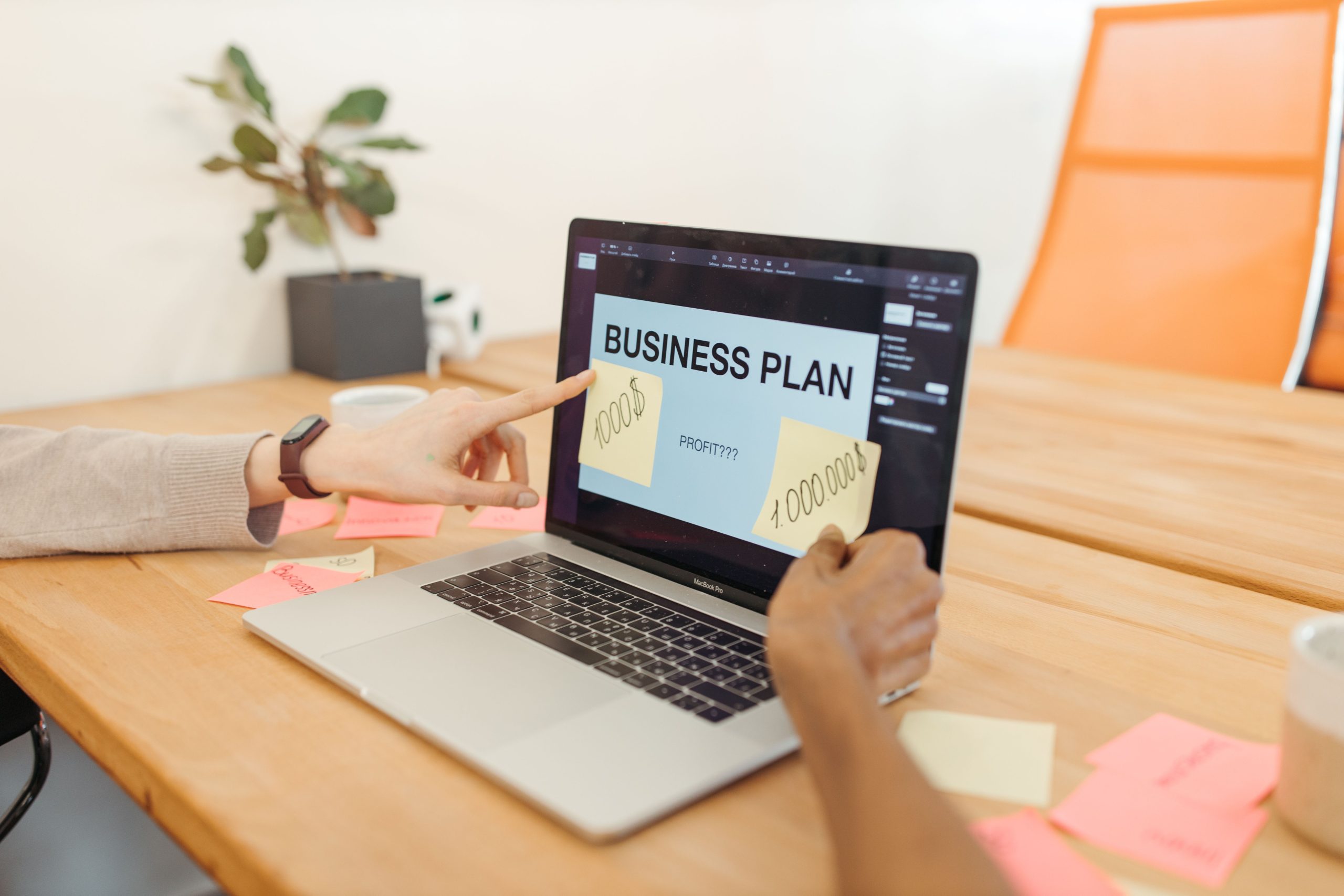 Mains collaborent sur plan d'affaires avec ordinateur portable
