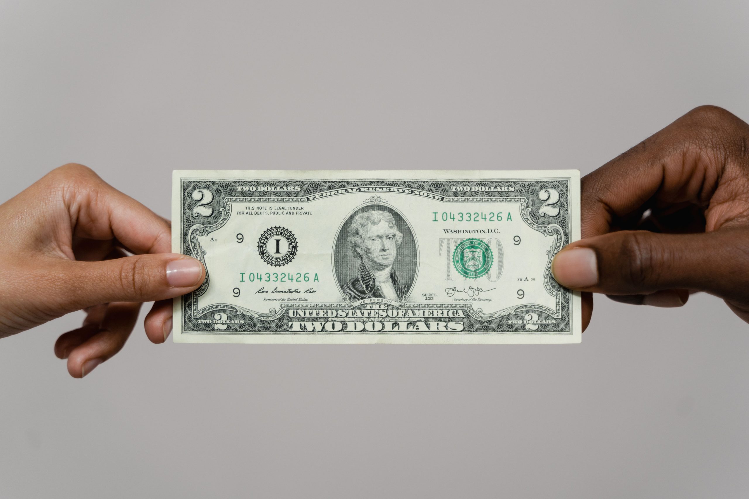 Deux mains échangeant billet dollars fond neutre