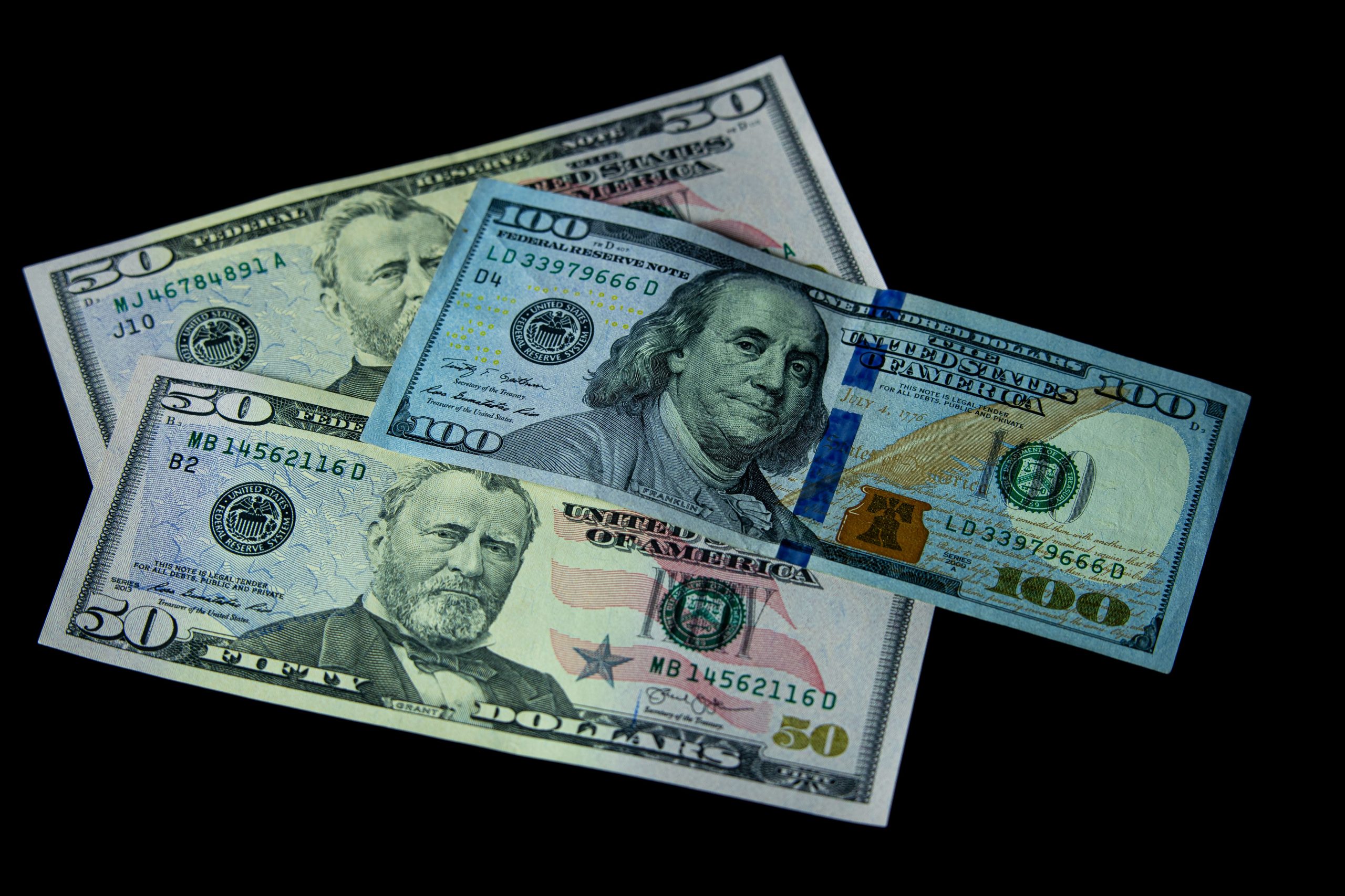 Billets USD 50 et 100 dollars sur fond noir