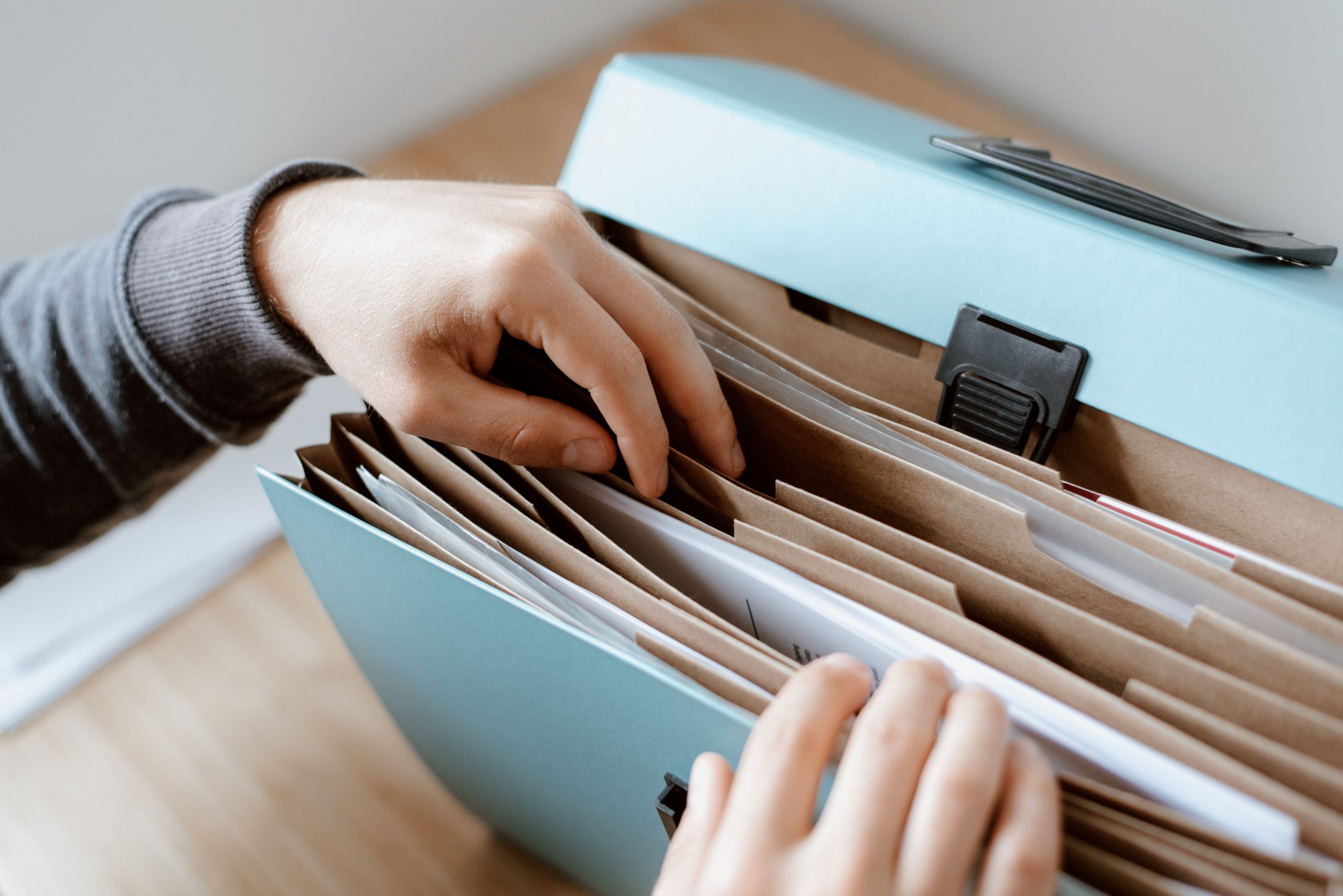 Personne sélectionnant des documents dans une mallette