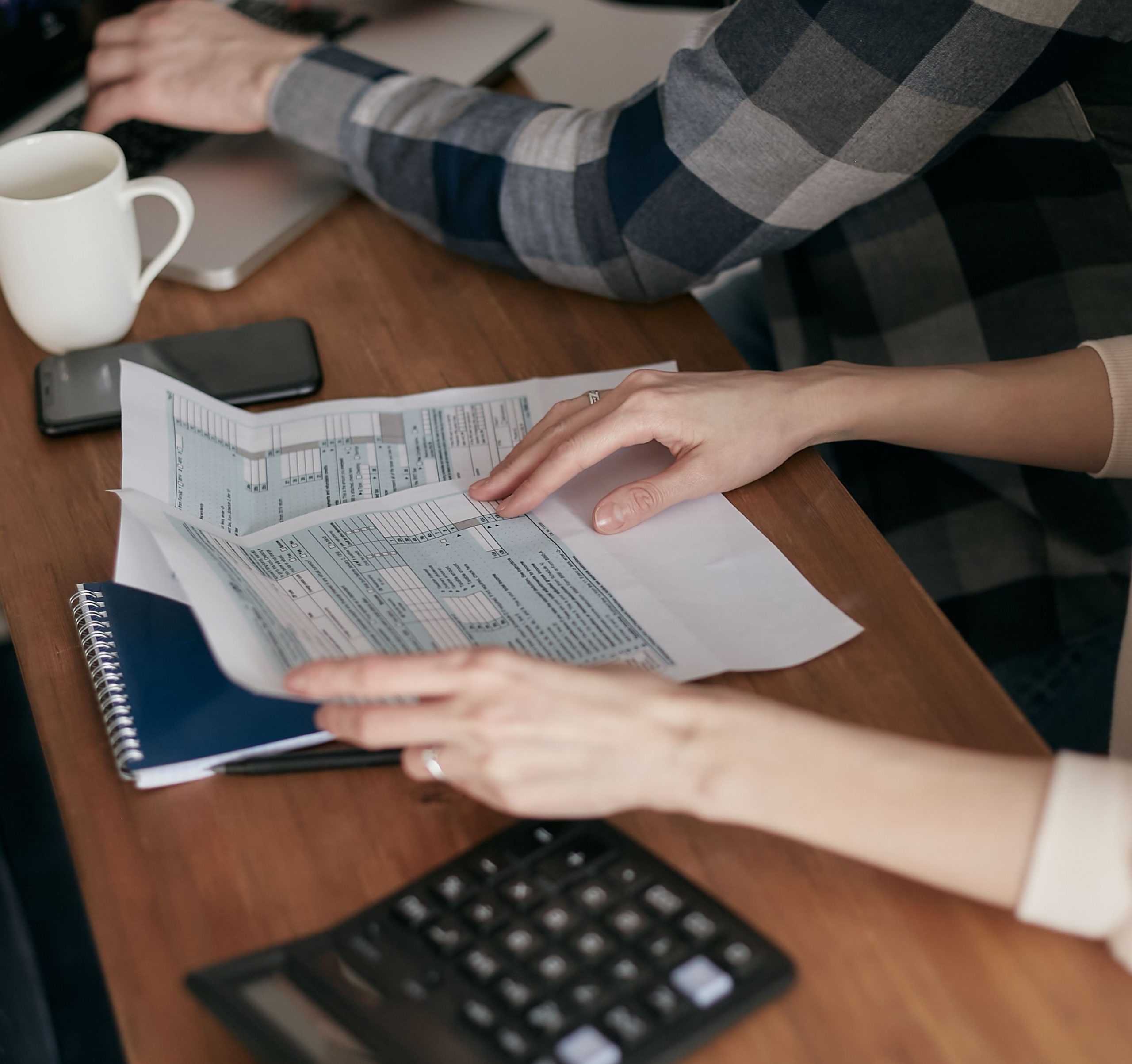 Mains organisant des documents fiscaux avec calculatrice