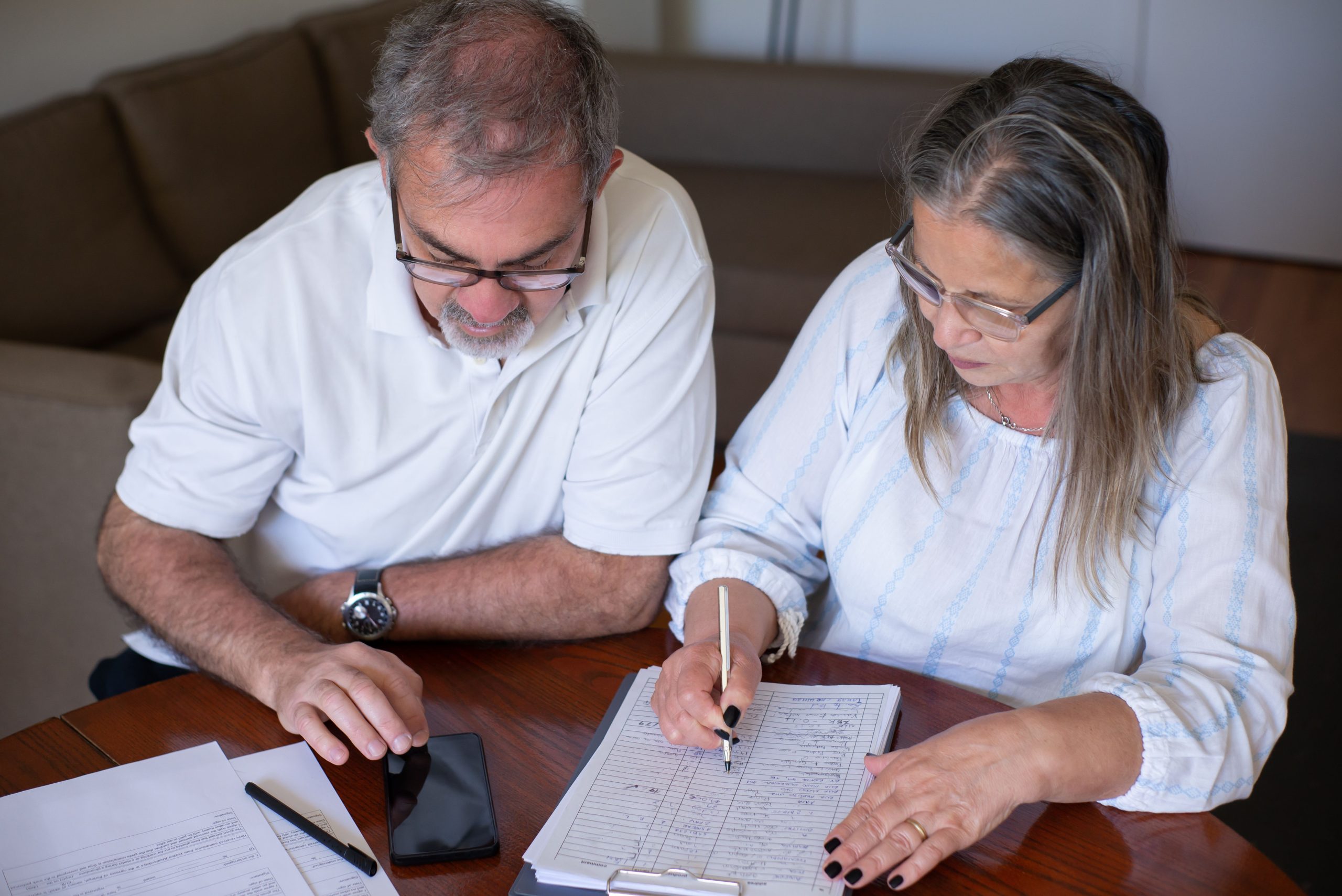 Couple senior consultant des documents sur smartphone
